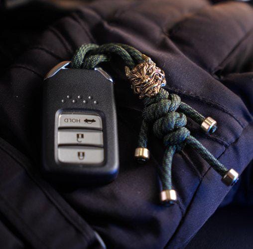 Brass Mythical Mask Paracord Keychain — EDC Backpack Charm & Car Ornament